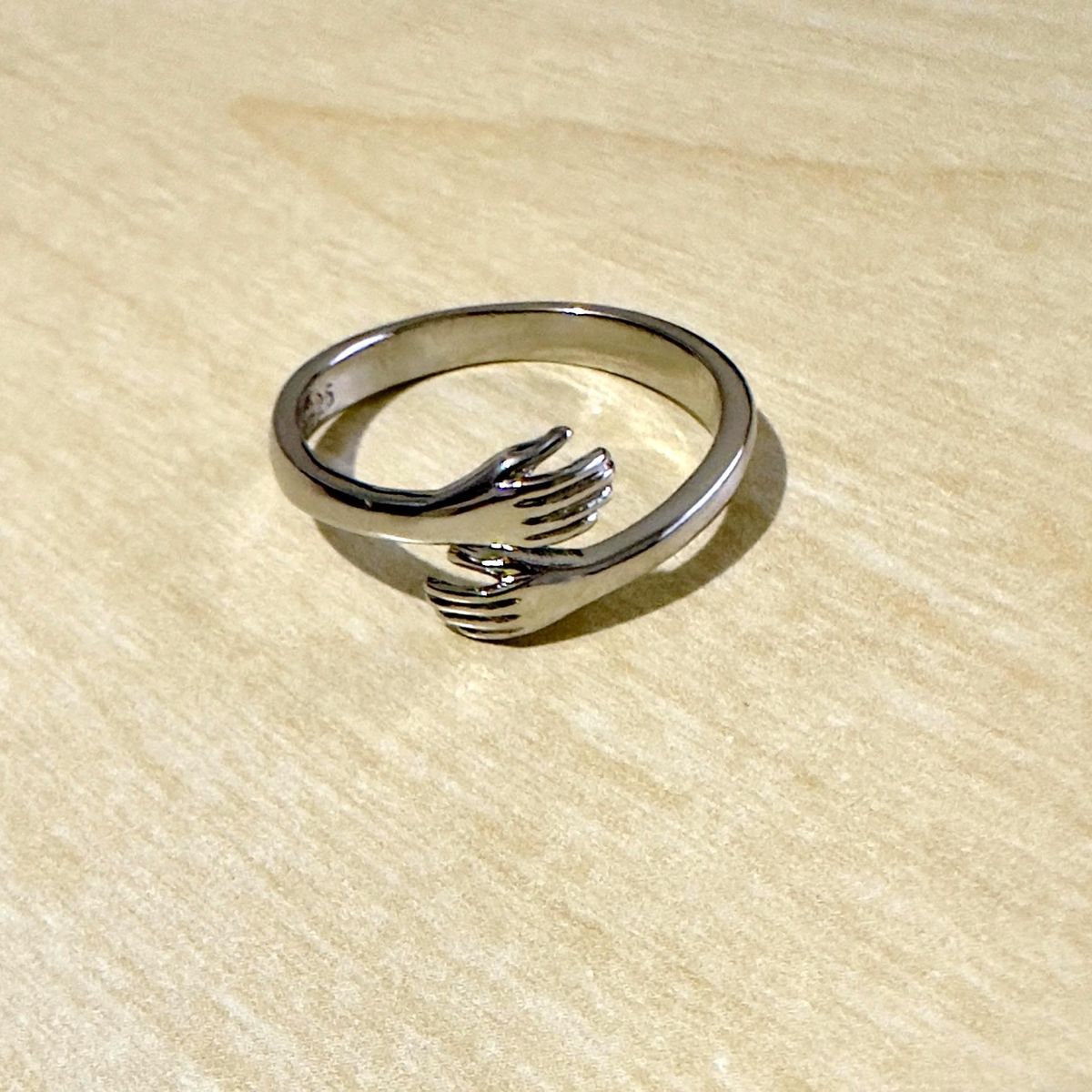 Silver promise ring with hugging hands design